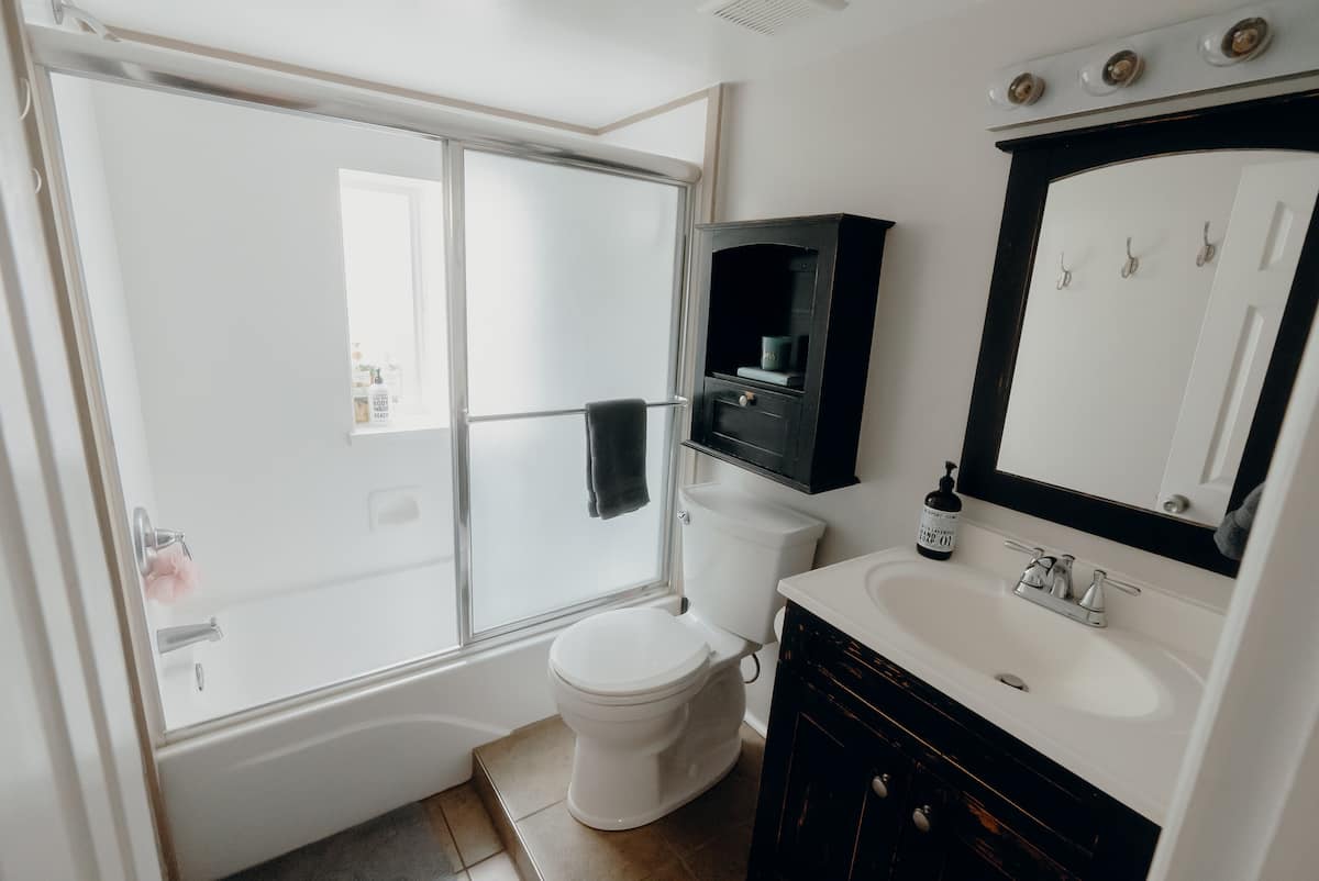 The apartment bathroom with tub, sink, and storage