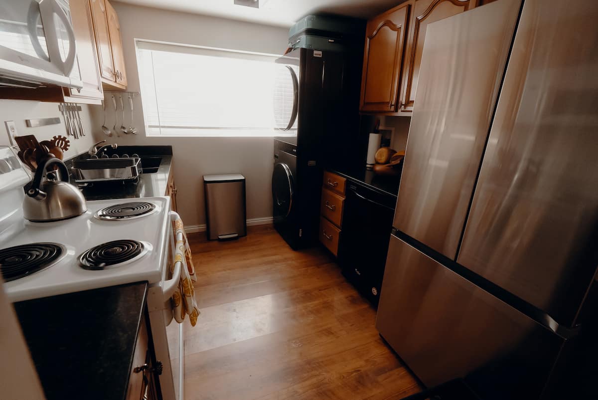 The apartment kitchen with appliances, cabinets, and laundry